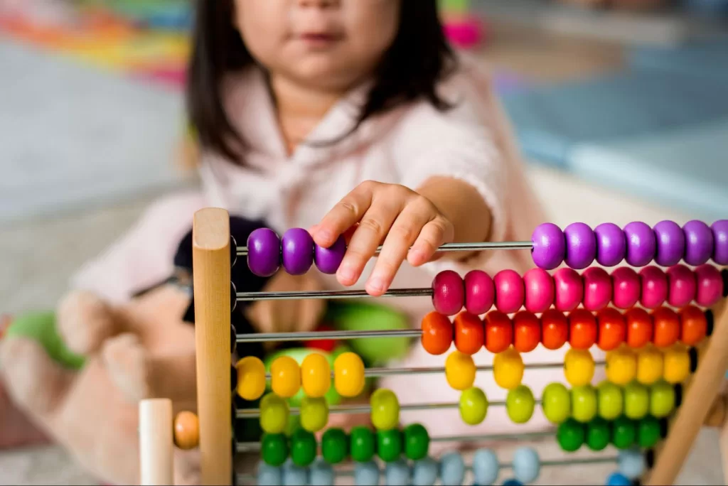 A child encounters an abacus for the first time.